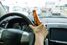 Person driving with a beer in hand